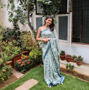 Model wearing The Biscuit Hour sage green cotton beagle print saree with daisy florals and dark teal zari pallu, Zoomies Collection Thread Weavers