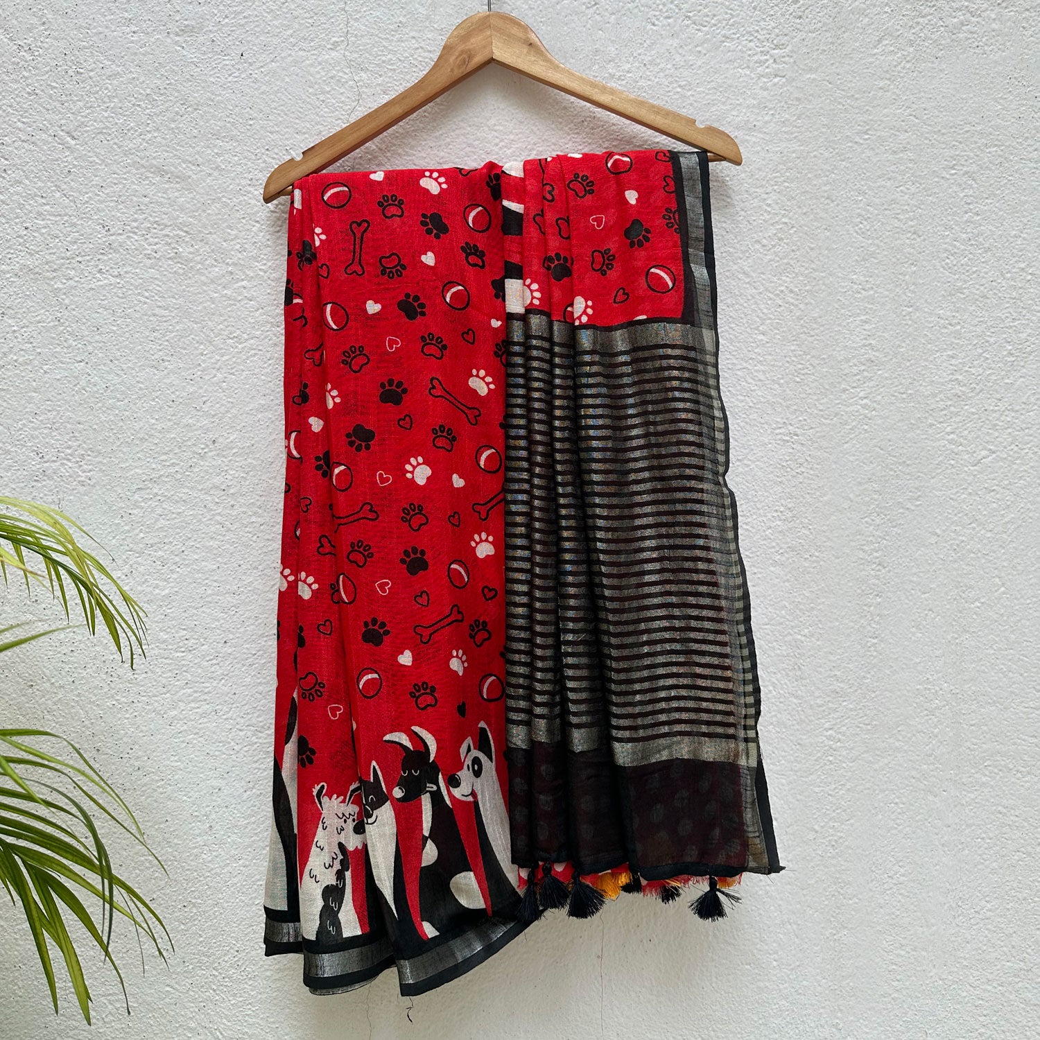 Bone Voyage red cotton dog print saree with paw print and bone motifs, illustrated dog border and black zari stripe pallu, Zoomies Collection
