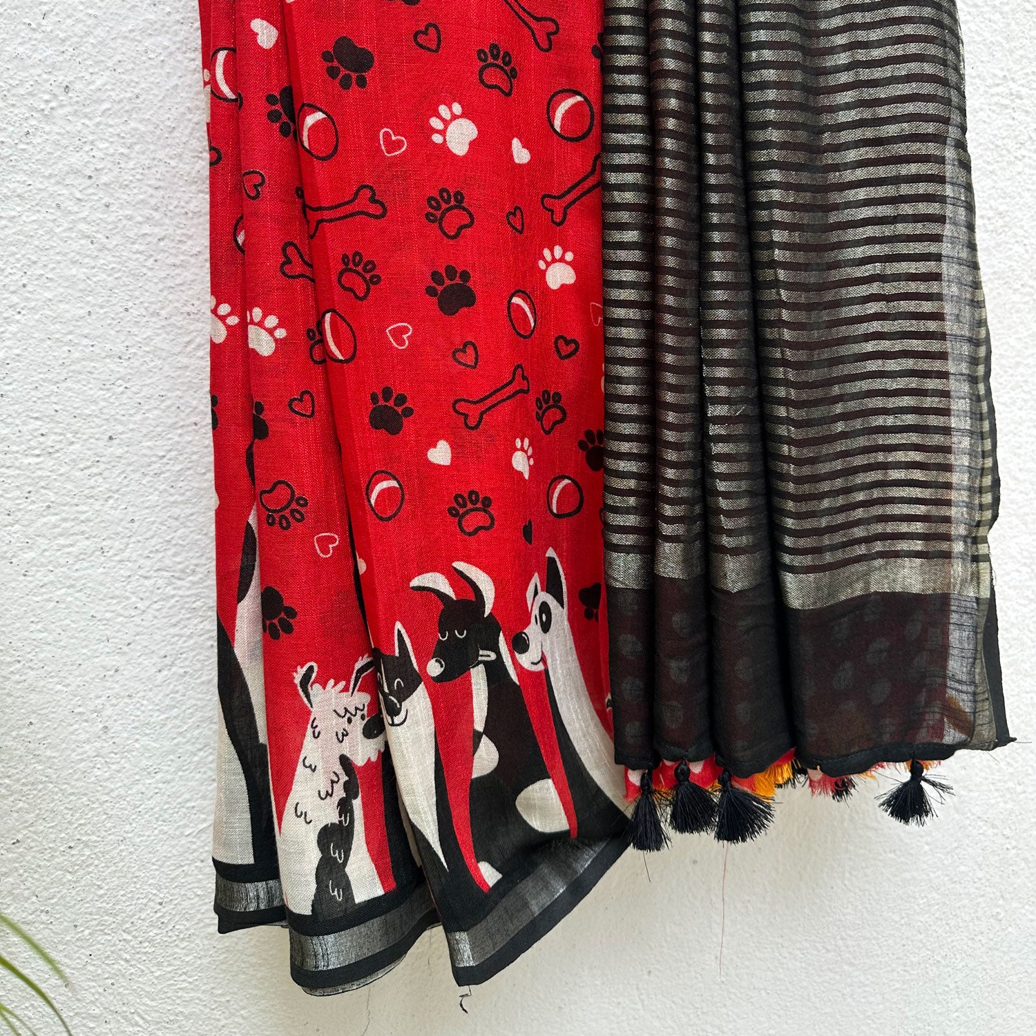 Bone Voyage red cotton dog print saree with paw print and bone motifs, illustrated dog border and black zari stripe pallu, Zoomies Collection