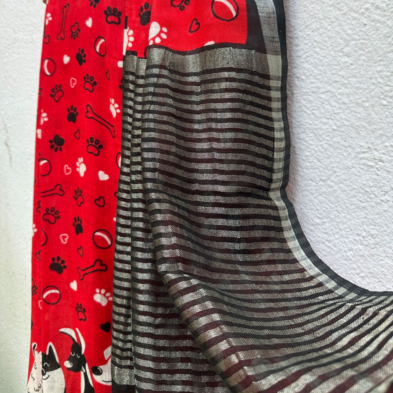 Bone Voyage red cotton dog print saree with paw print and bone motifs, illustrated dog border and black zari stripe pallu, Zoomies Collection