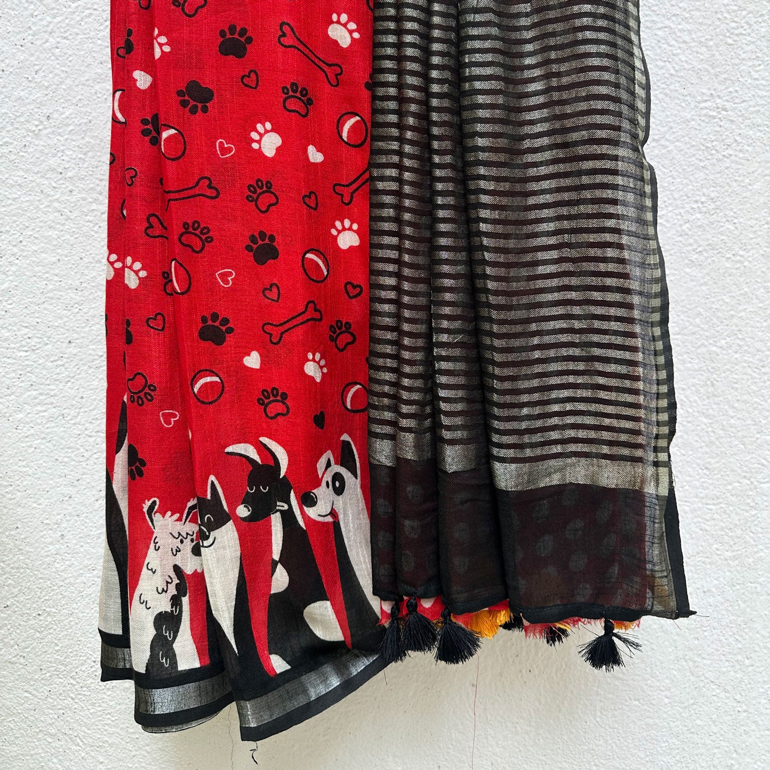 Bone Voyage red cotton dog print saree with paw print and bone motifs, illustrated dog border and black zari stripe pallu, Zoomies Collection