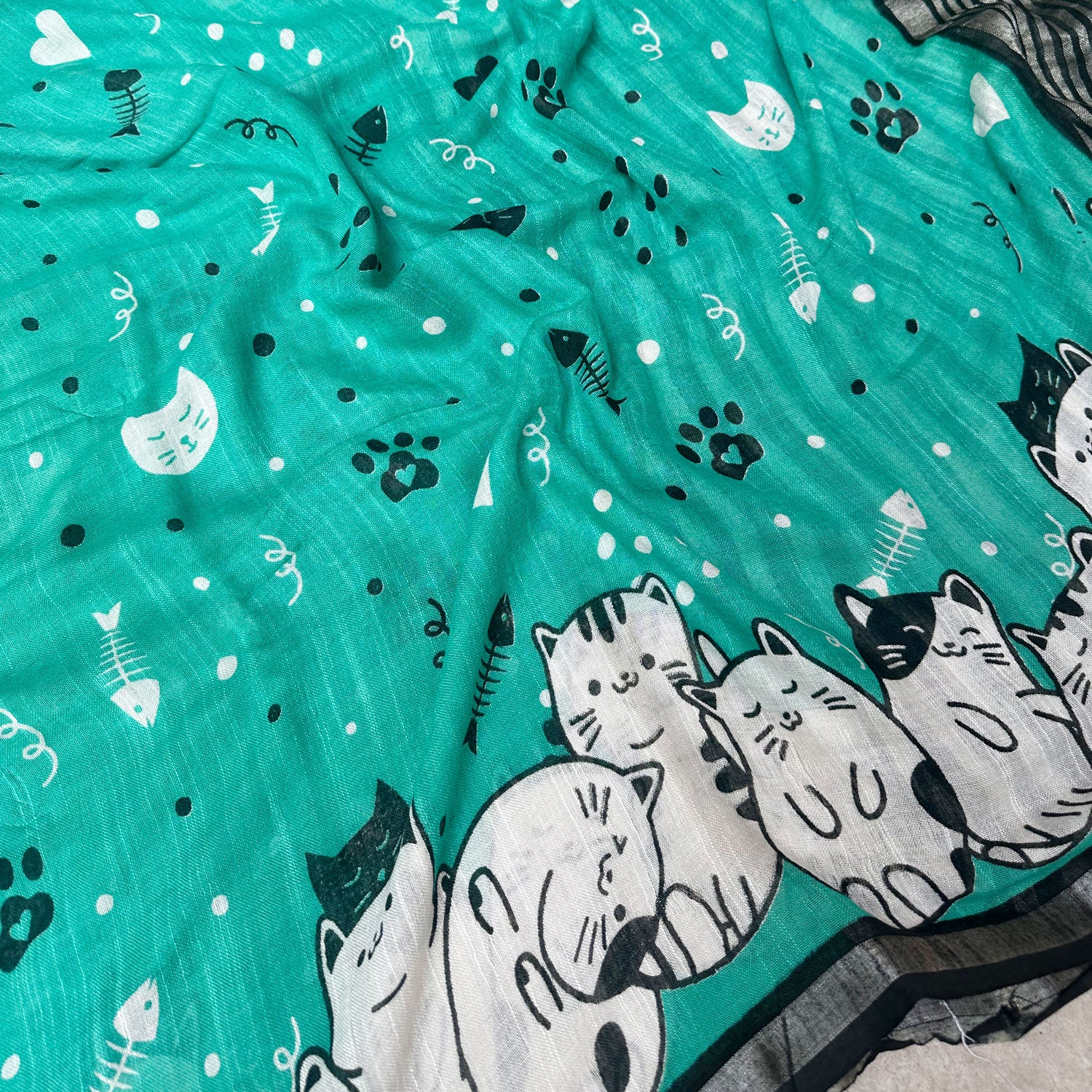 Cat Nap Playtime teal cotton print saree closeup with fishbone motifs, sleeping cat border and black stripe zari pallu, Zoomies Collection