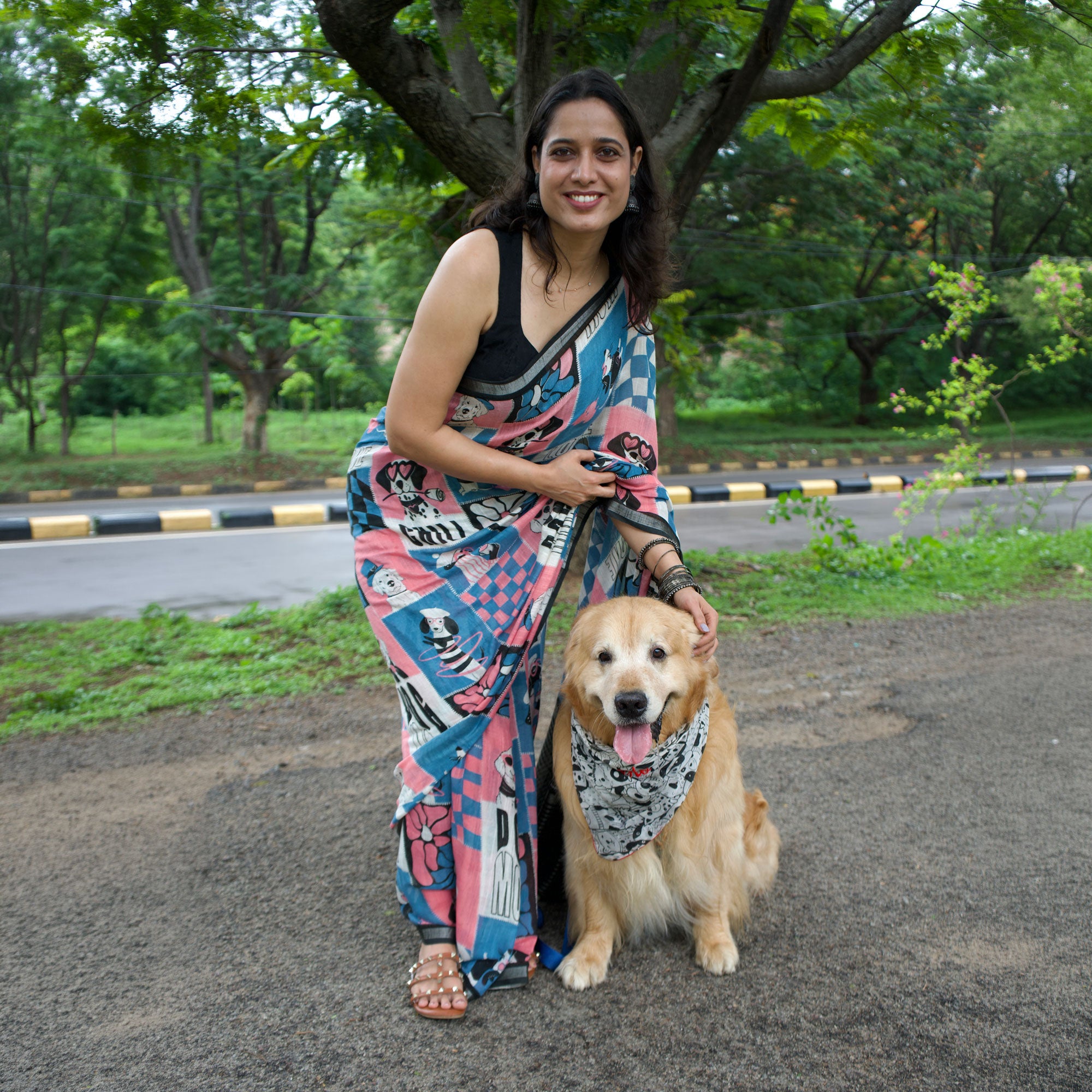 Model wearing Dog Mom Actually pink blue patchwork dog print saree with illustrated dog panels and black zari pallu, Zoomies Collection Thread Weavers. Pablo her baby in the The Thread Weaver's Bandana