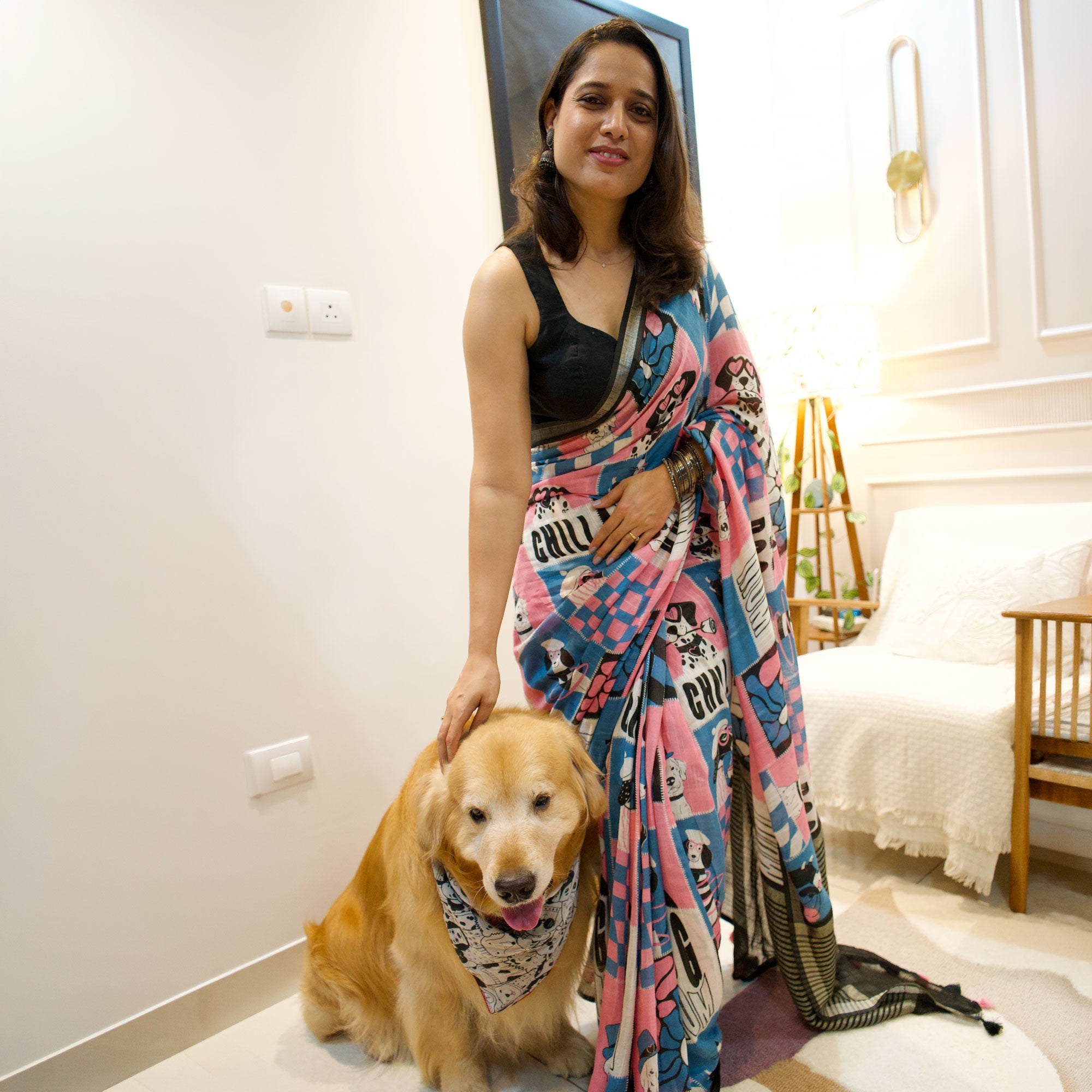 Model wearing Dog Mom Actually pink blue patchwork dog print saree with illustrated dog panels and black zari pallu, Zoomies Collection Thread Weavers. Pablo her baby in the The Thread Weaver's Bandana