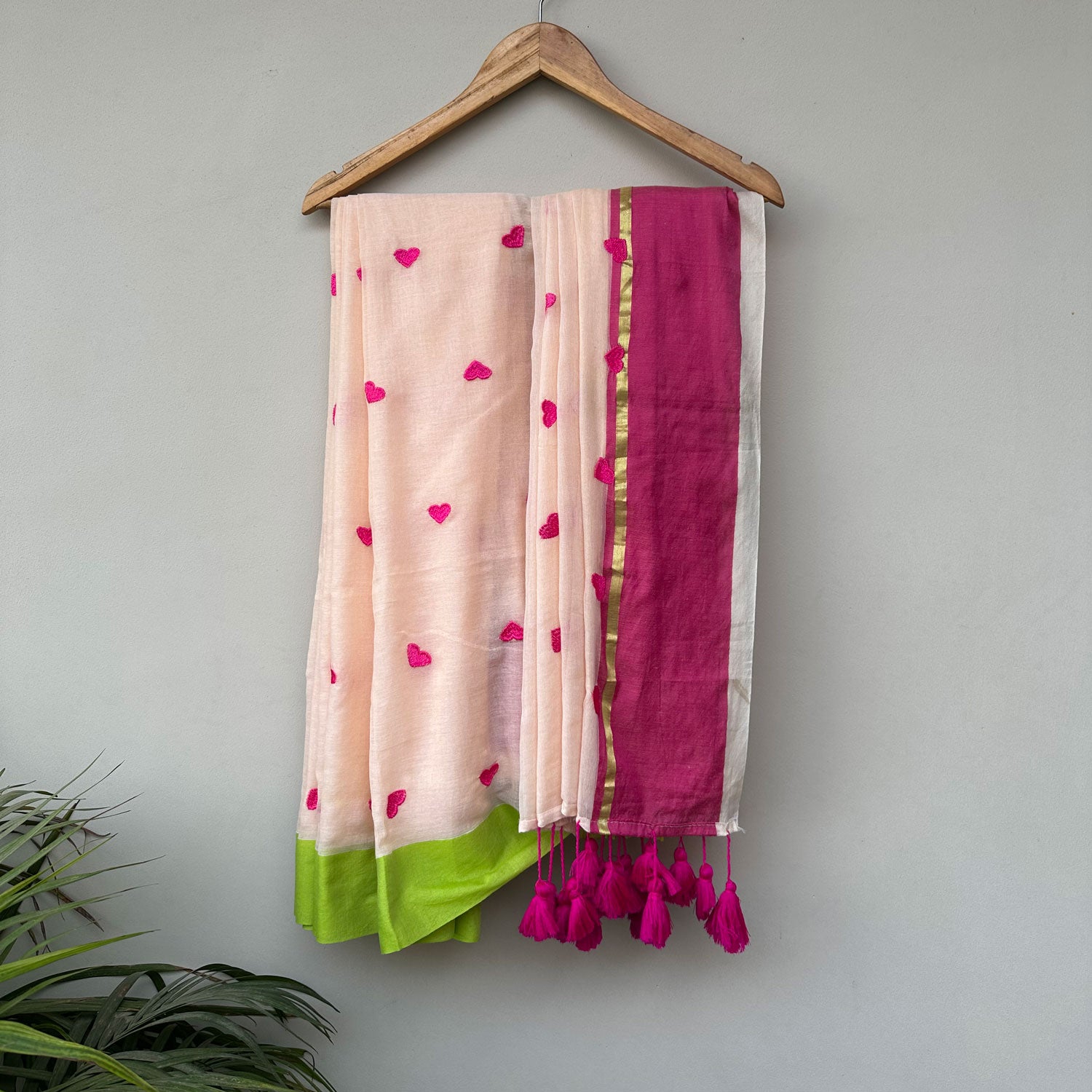 Guava Bloom mul cotton saree in blush pink with embroidered heart motifs, lime green border and handcrafted tassels.