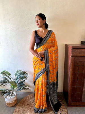Model wearing Zebra Cadabra orange printed cotton saree with zebra motifs and grey border, styled with minimal jewellery and black blouse, by The Thread Weavers