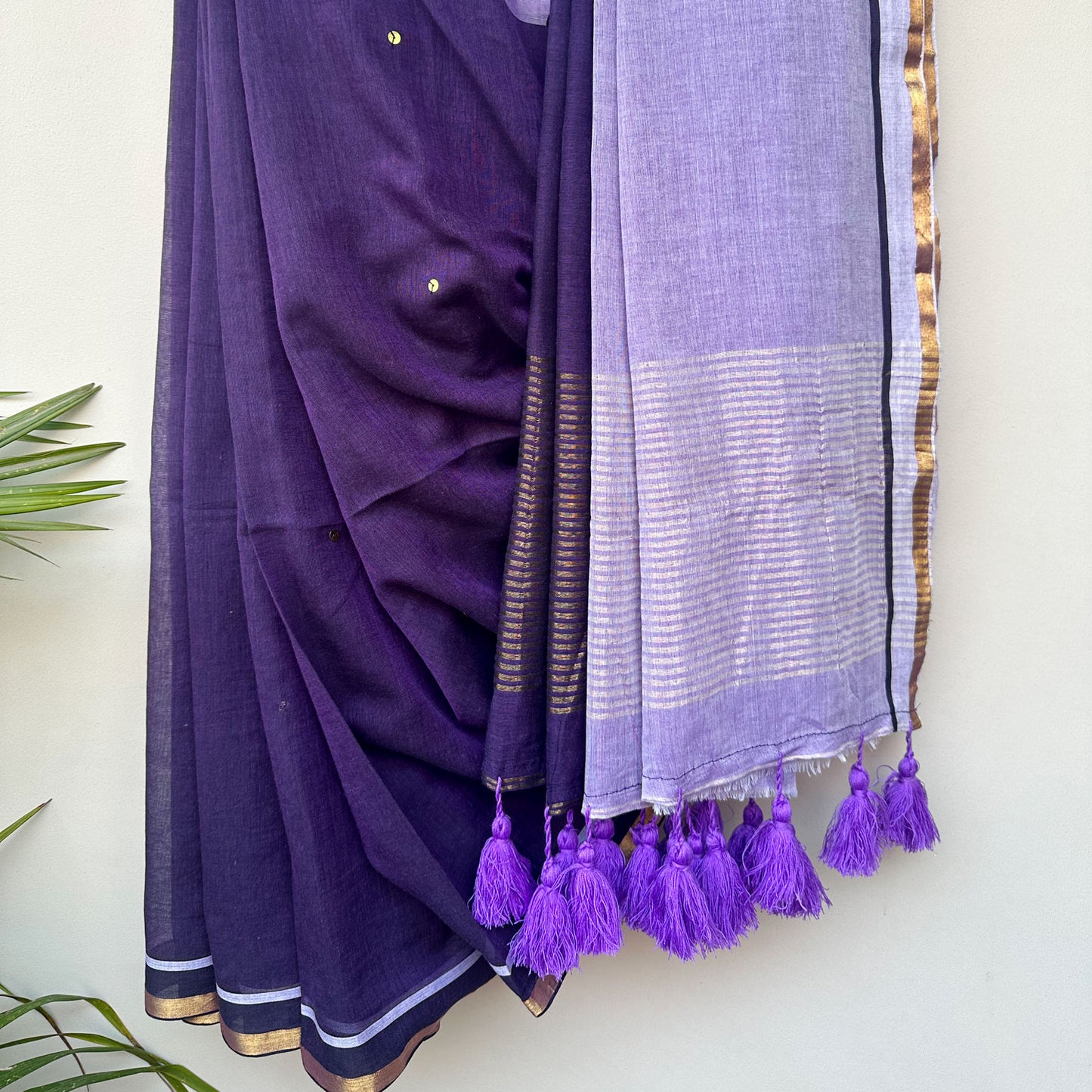 Jamuni Dhoop embroidered saree showcasing an airy mul cotton drape, deep purple hues and handcrafted tassels.