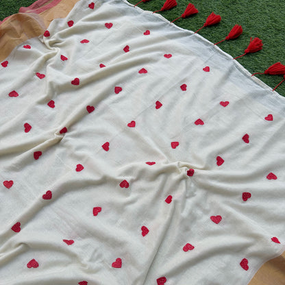 Red embroidered heart motifs on an ivory mul cotton saree with subtle gold border detailing.