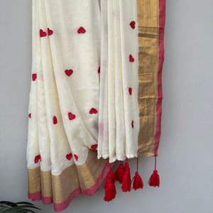 Lightweight mul cotton saree in ivory with scattered red heart motifs and elegant gold border accents.