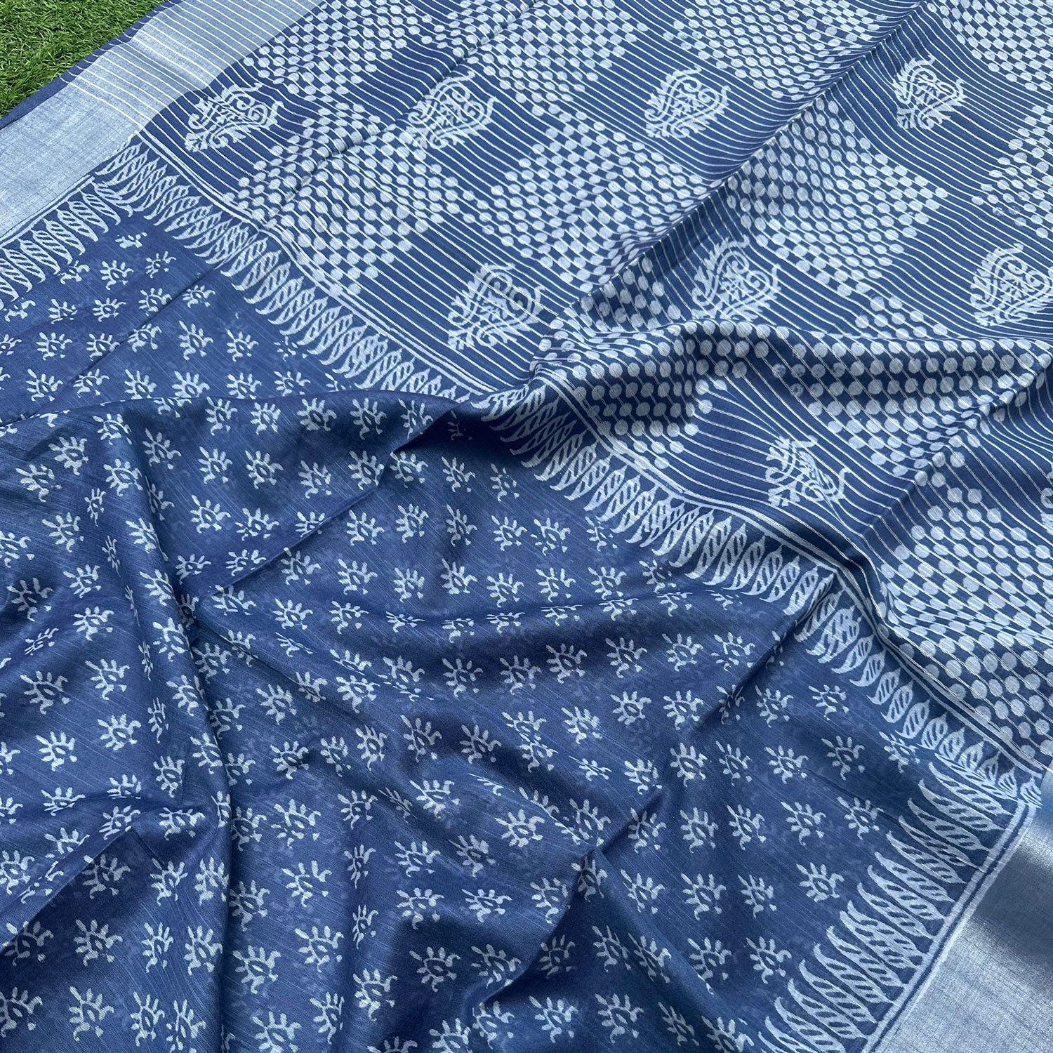 Closeup of sun buti scatter print and feathered leaf paisley border on indigo cotton silk – Manah