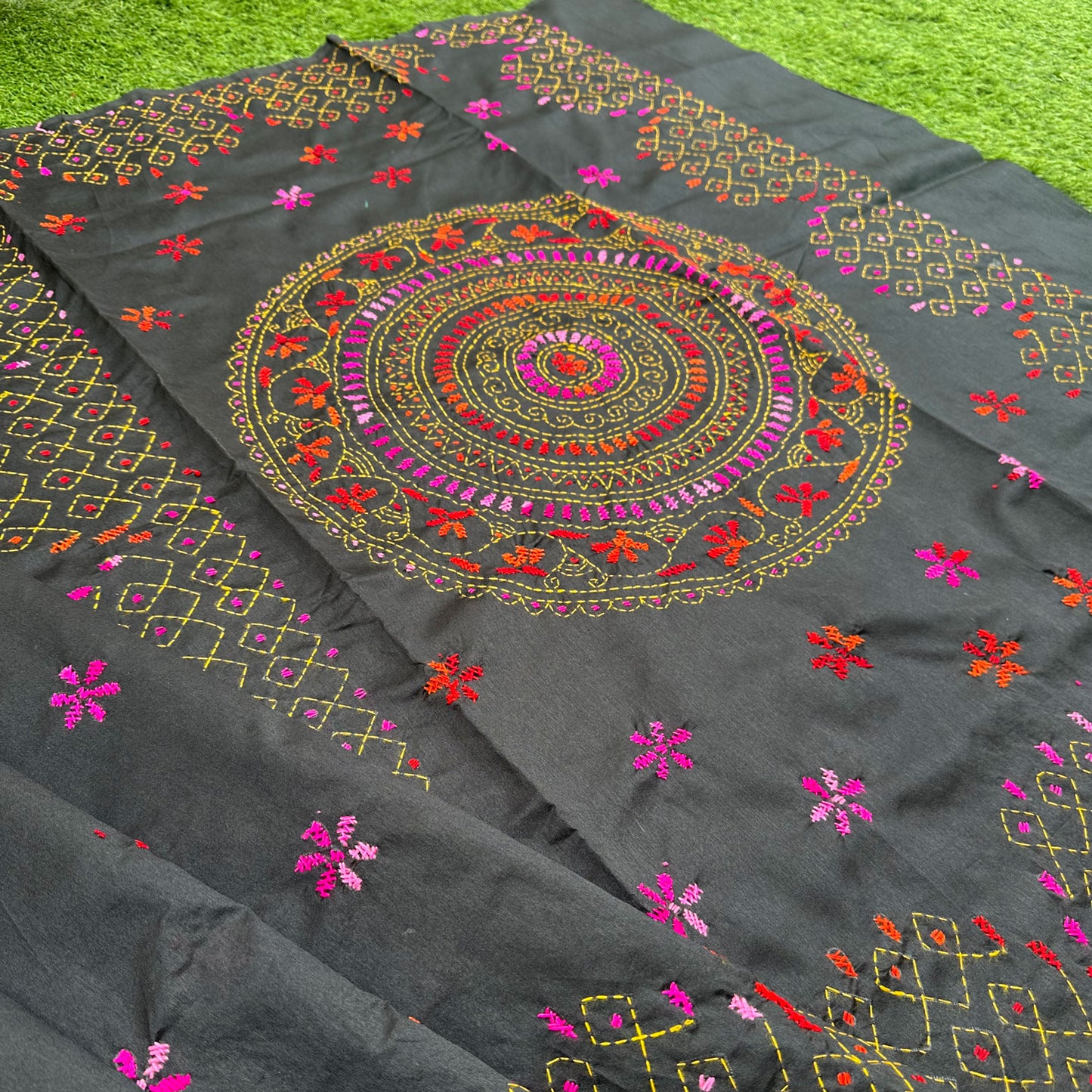 Black Kantha embroidered saree featuring a vibrant circular medallion motif with colourful hand embroidery and geometric borders.
