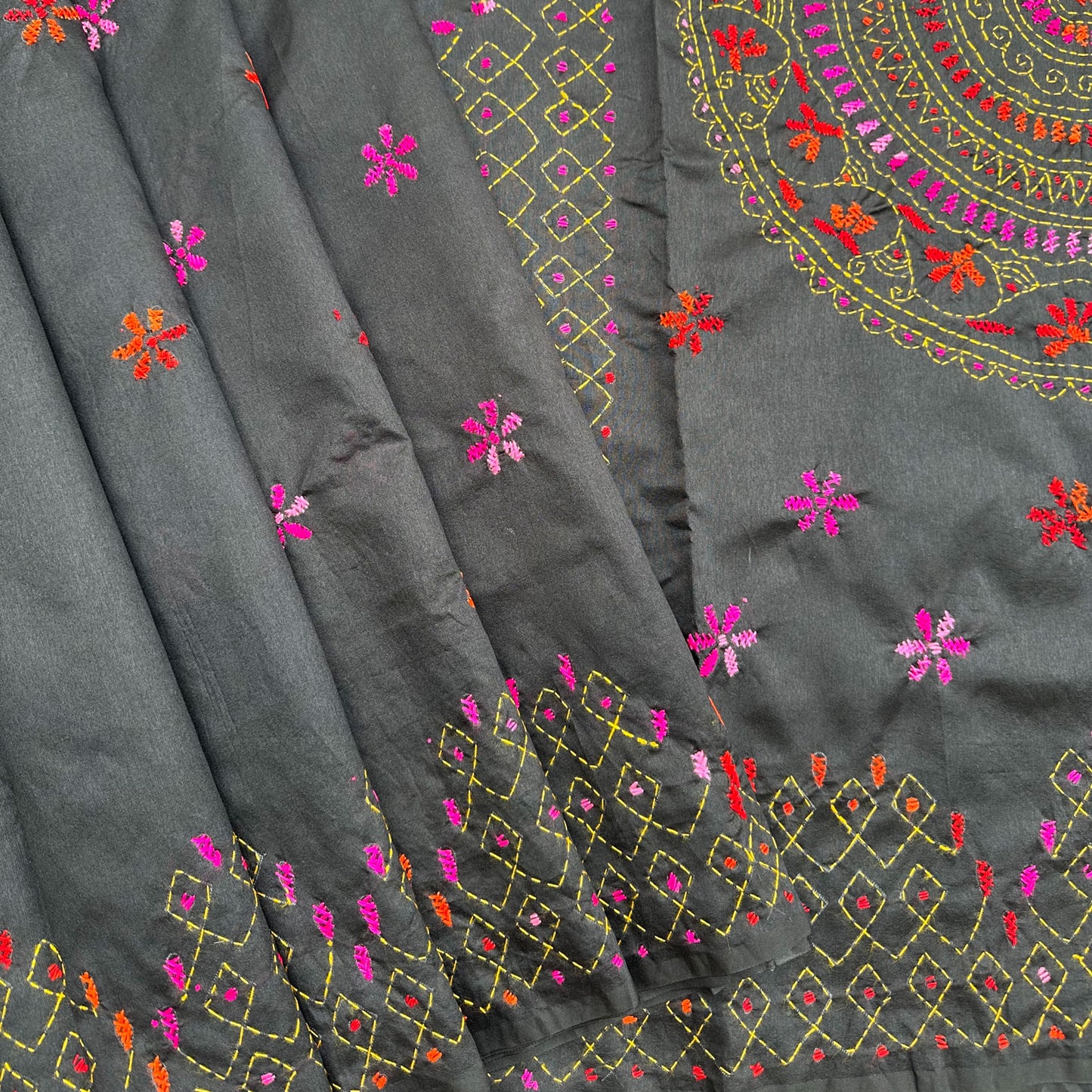 Handcrafted black Kantha saree with intricate circular embroidery, floral motifs and colourful folk-inspired detailing.