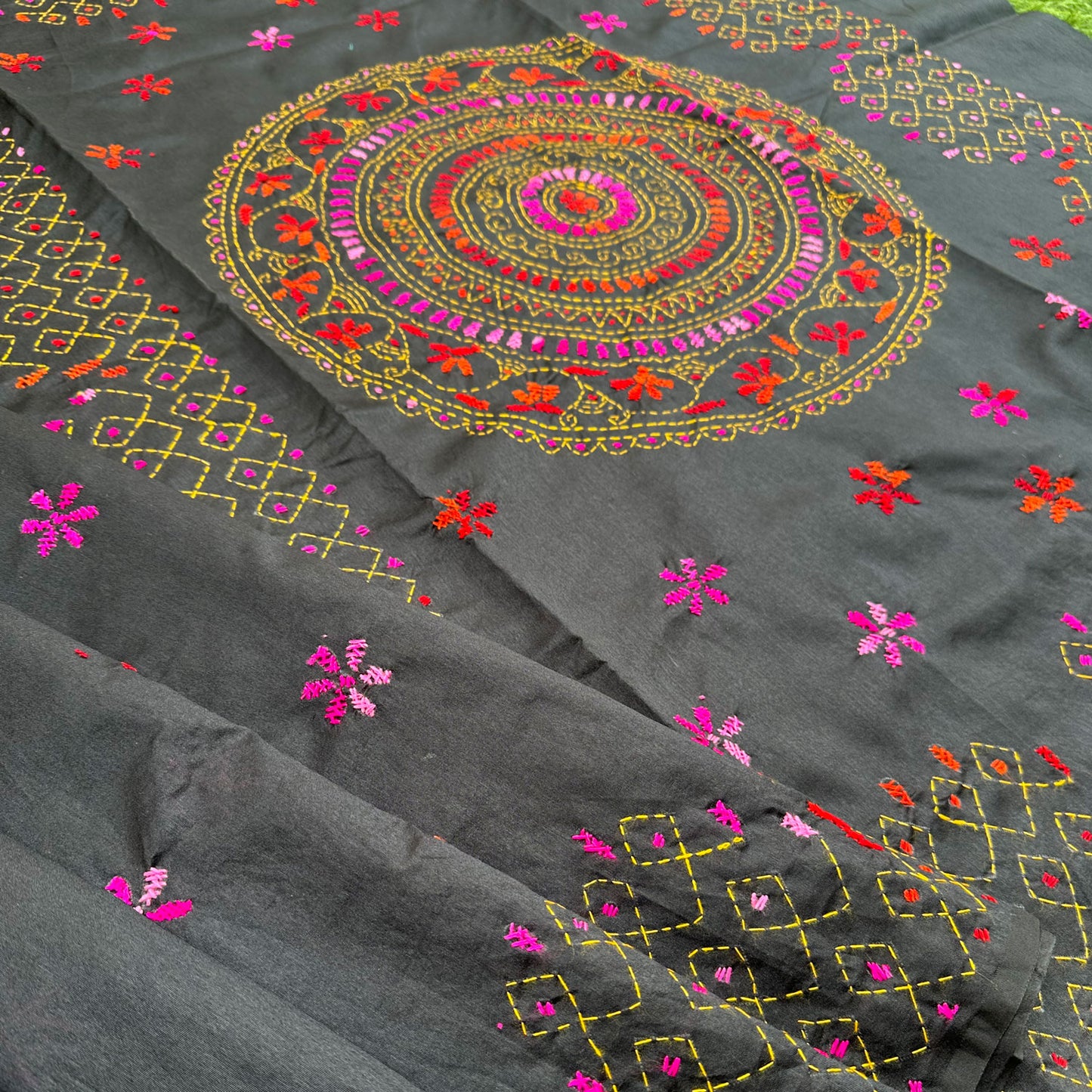 Contemporary black embroidered saree showcasing Kantha stitch artistry in pink, orange and red threadwork.