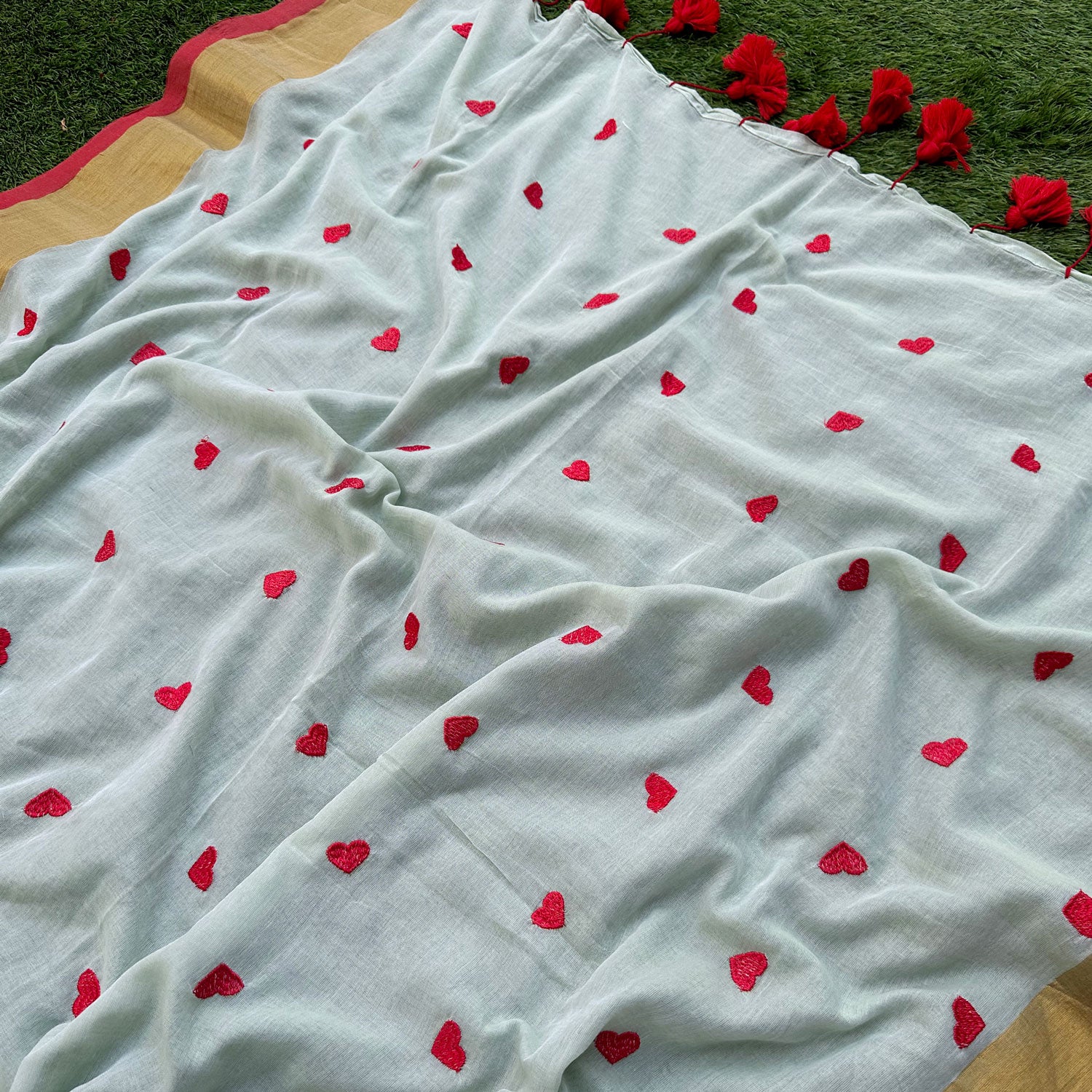 Handcrafted embroidered mul saree with playful heart motifs, breathable drape and modern Indian styling.