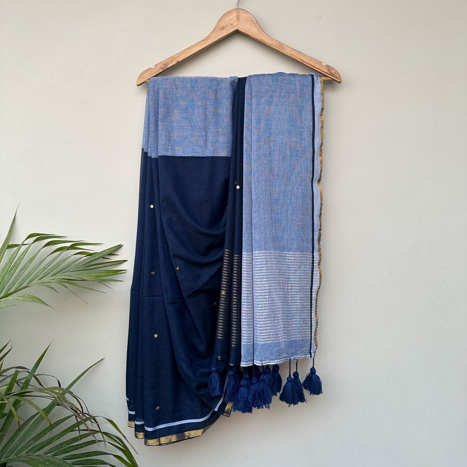 Mul cotton saree in midnight blue with powder blue pallu, delicate embroidery and handcrafted tassels.