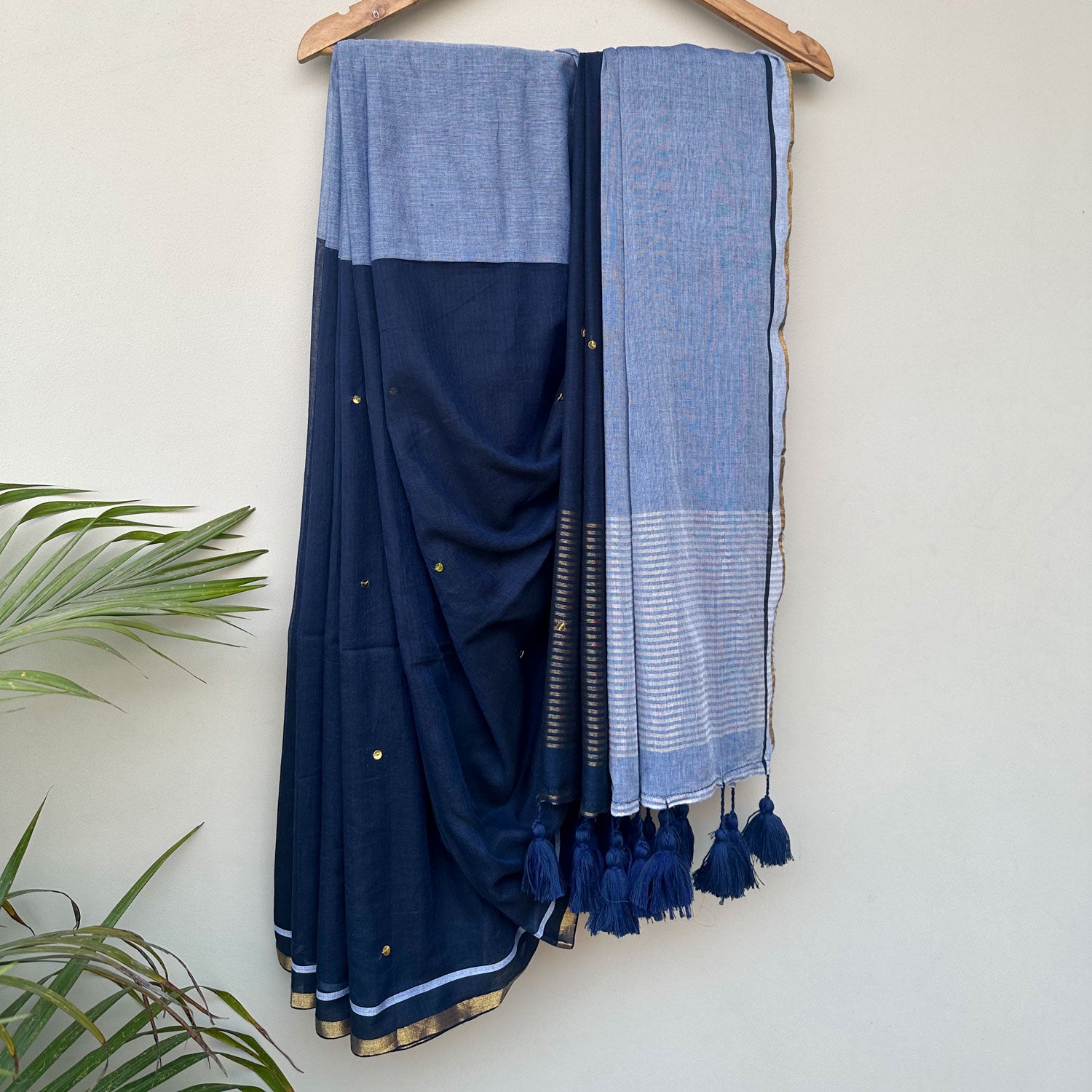 Contemporary blue mul cotton saree featuring subtle embroidered motifs, striped pallu and lightweight drape.