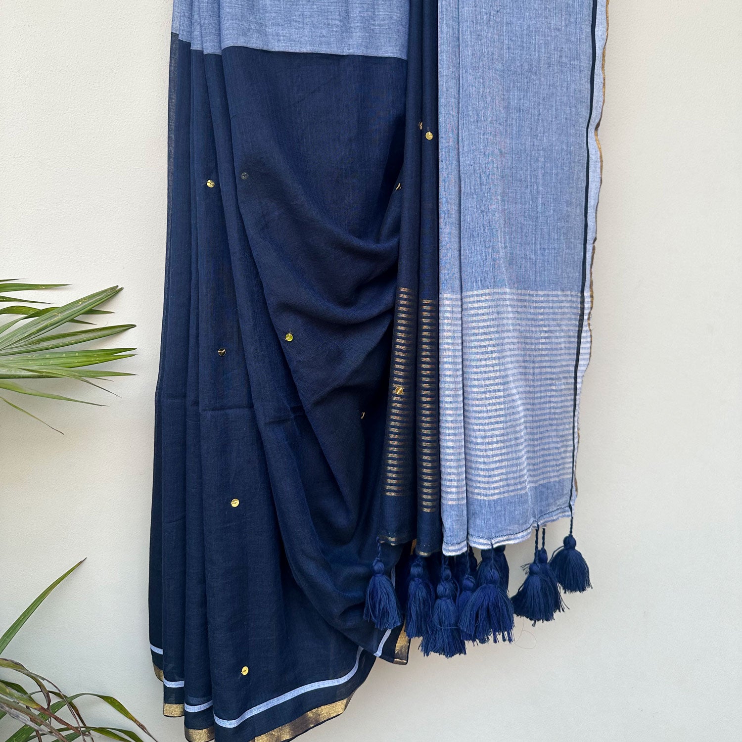 Midnight blue mul saree with soft powder blue accents, delicate embroidery and tassel detailing.
