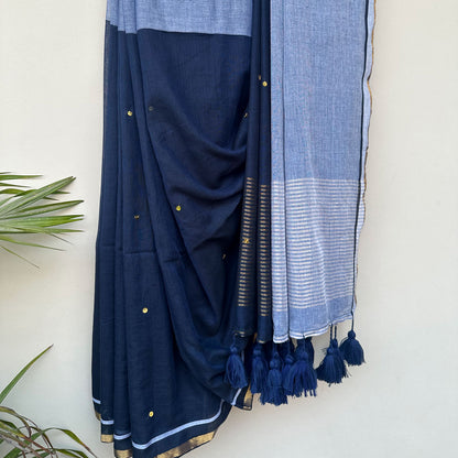 Midnight blue mul saree with soft powder blue accents, delicate embroidery and tassel detailing.