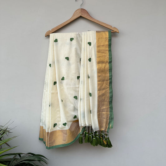 Olive Crush ivory mul cotton saree with green embroidered heart motifs, gold border and handcrafted green tassels.