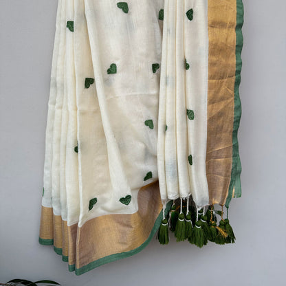 Contemporary ivory mul saree featuring delicate green heart embroidery and earthy olive-toned accents.