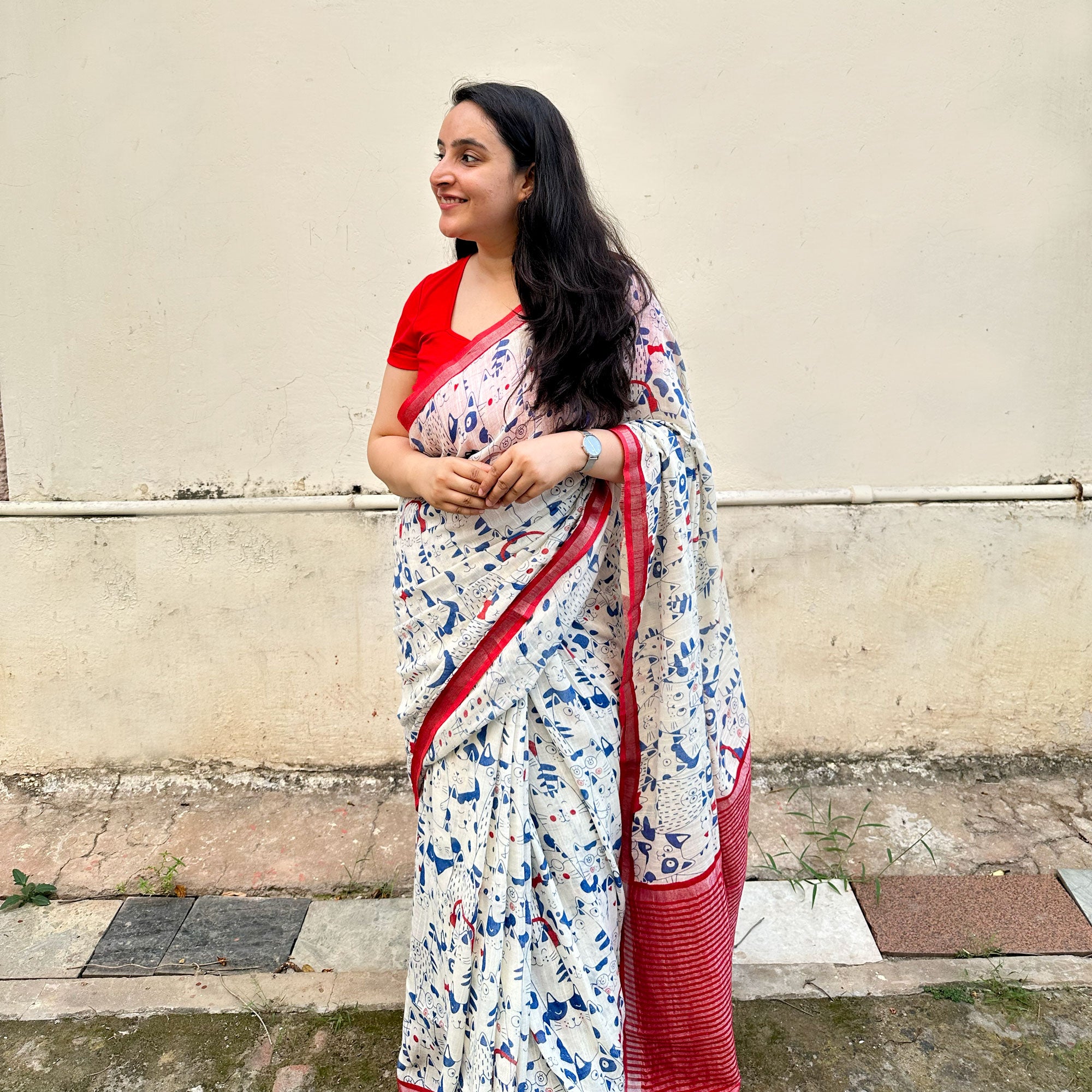 Founder wearing Purr-suasion ivory cotton saree with blue illustrated cat crowd print and bold red zari pallu paired with red blouse, Zoomies Collection by Thread Weavers