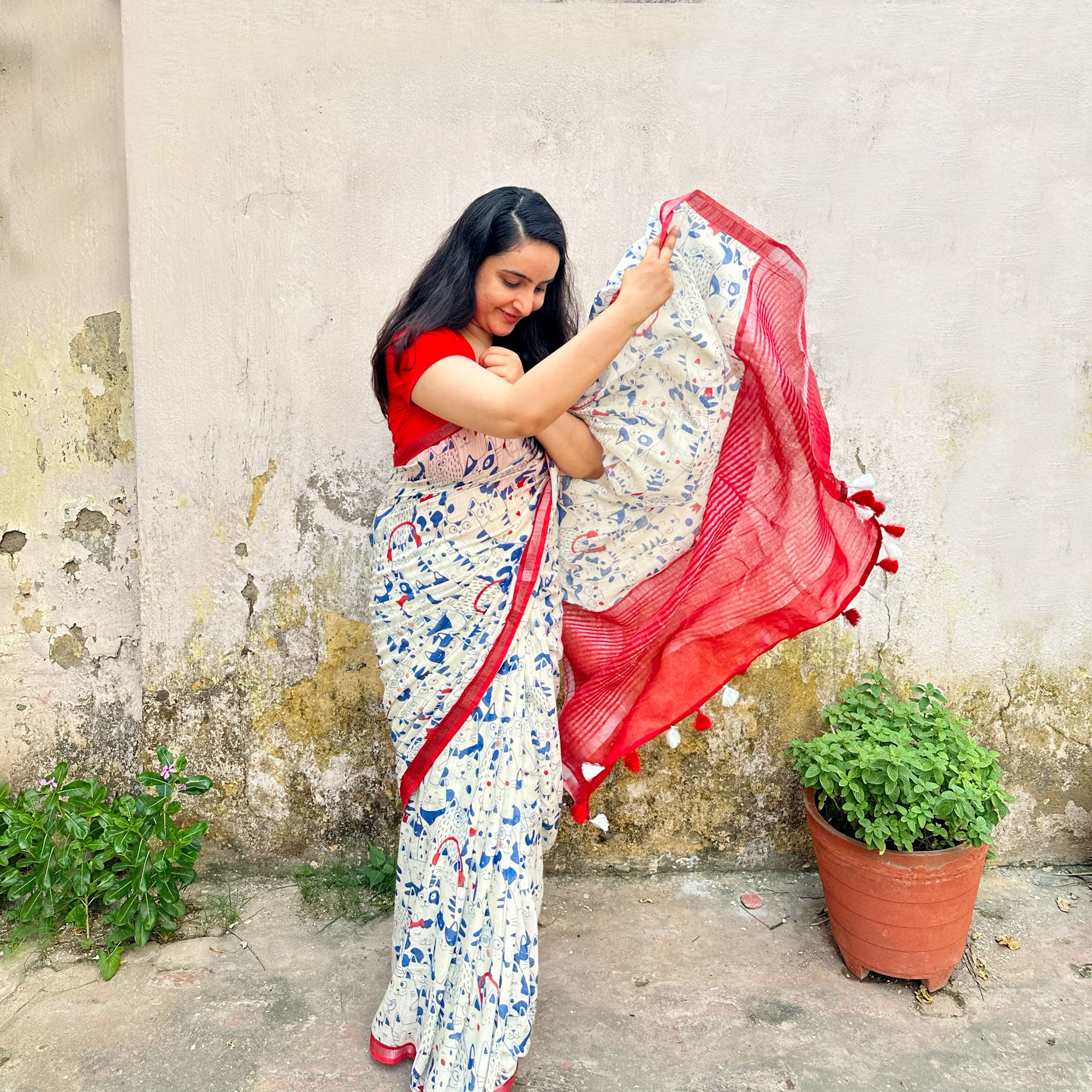 Founder wearing Purr-suasion ivory cotton saree with blue illustrated cat crowd print and bold red zari pallu paired with red blouse, Zoomies Collection by Thread Weavers