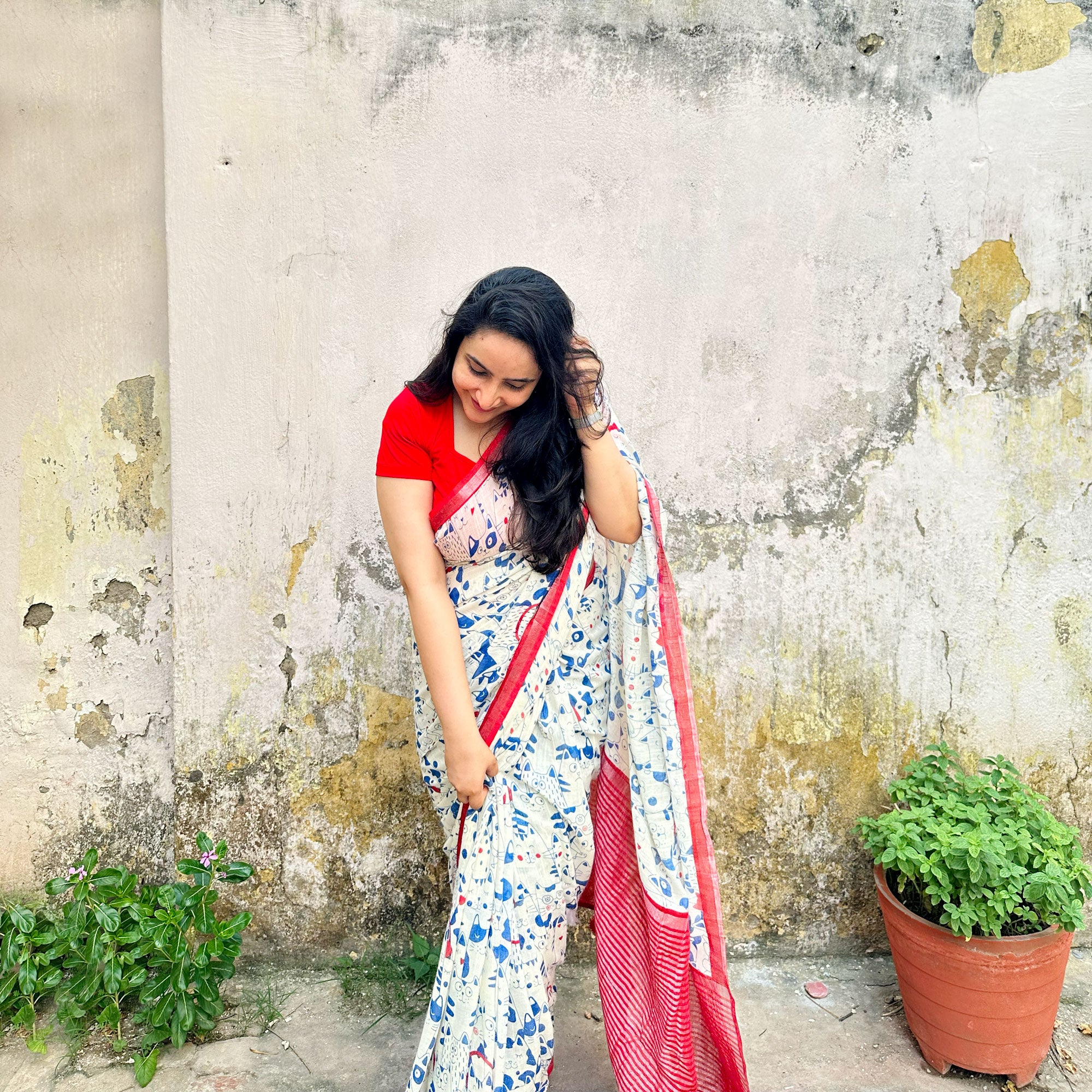 Founder wearing Purr-suasion ivory cotton saree with blue illustrated cat crowd print and bold red zari pallu paired with red blouse, Zoomies Collection by Thread Weavers