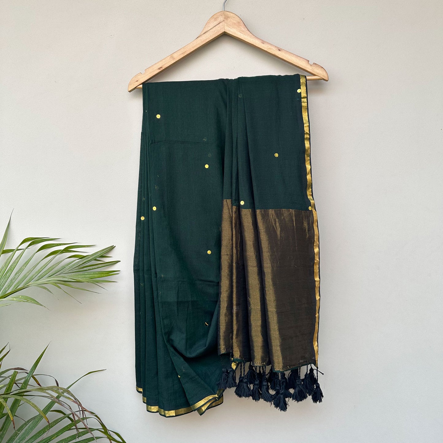 Rainforest green mul cotton saree with delicate gold motifs, contrast pallu and handcrafted tassel detailing.
