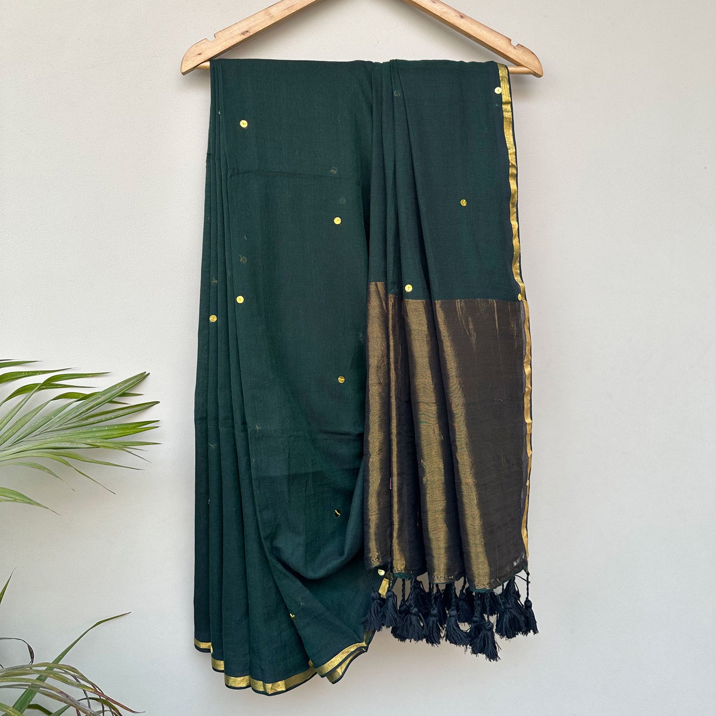 Contemporary forest green mul saree featuring subtle embroidered motifs and lightweight breathable drape.
