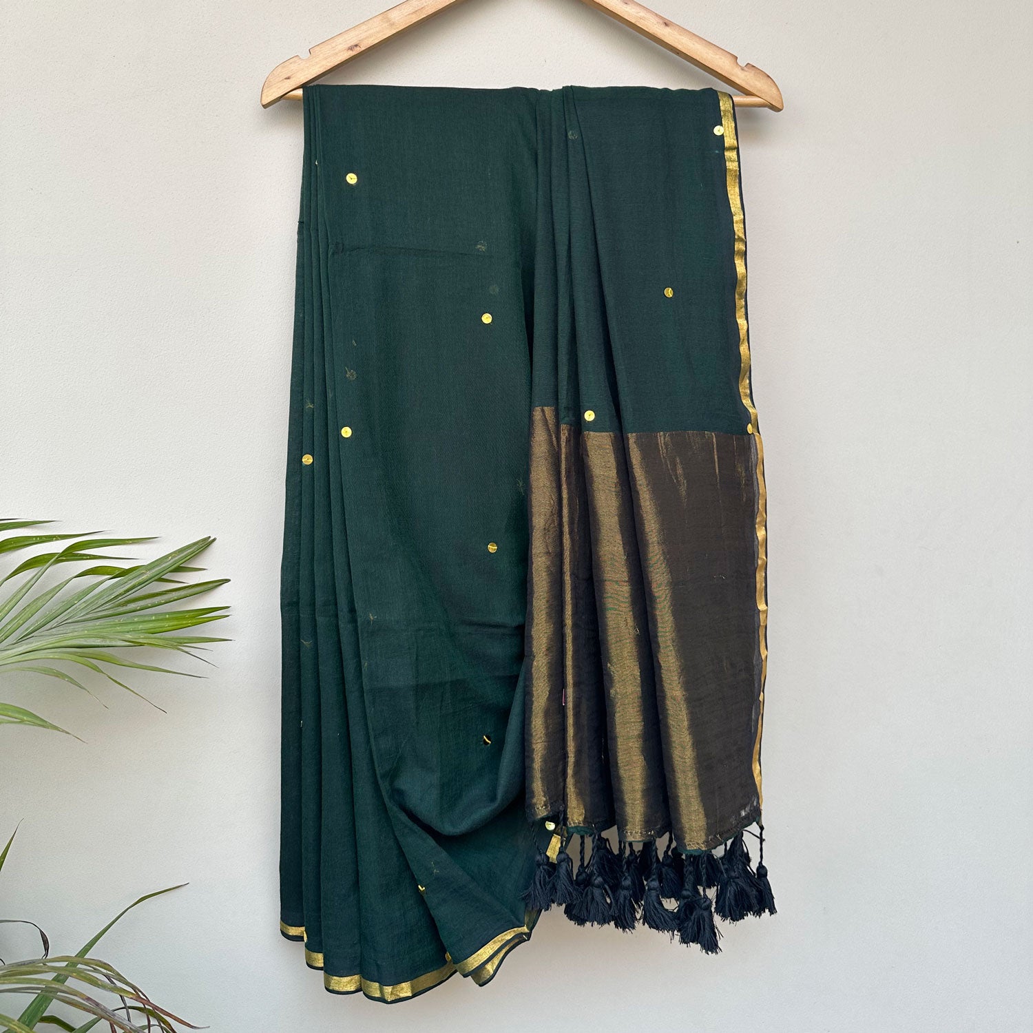 Contemporary forest green mul saree featuring subtle embroidered motifs and lightweight breathable drape.
