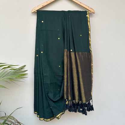 Contemporary forest green mul saree featuring subtle embroidered motifs and lightweight breathable drape.