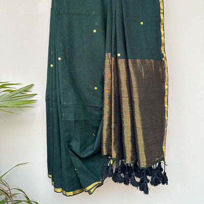 Vanika mul cotton saree showcasing an airy drape, forest green tones and elegant tassel finish.