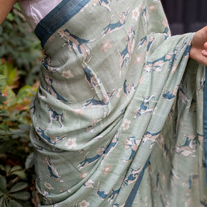 Model wearing The Biscuit Hour sage green cotton beagle print saree with daisy florals and dark teal zari pallu, Zoomies Collection Thread Weavers