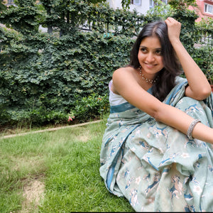 Model wearing The Biscuit Hour sage green cotton beagle print saree with daisy florals and dark teal zari pallu, Zoomies Collection Thread Weavers